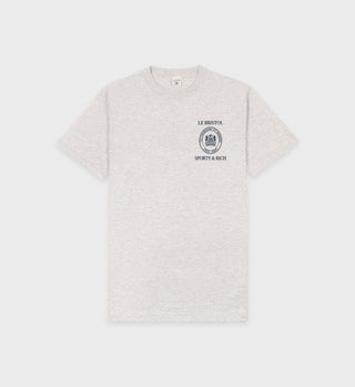 The Crest Seal 100th T-Shirt in heather gray/navy features LE BRISTOL and SPORTY & RICH text with a blue logo on the left chest. It is oversized and made from 100% cotton.