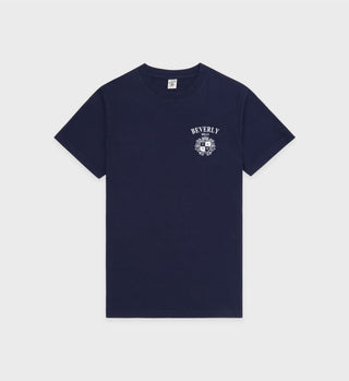 Beverly Hills Crest Soft T-Shirt in navy/white, featuring a pre-shrunk cotton fabric with a white BEVERLY and crest design on the upper left chest, made in Portugal, displayed on a plain background.