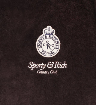 The Crown Velour V-Neck in Chocolate/Cream features the Sporty & Rich Country Club logo and circular crest embroidered on dark 100% cotton fabric.