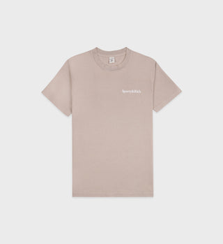 The Drink More Water T-Shirt - Elephant/White is a light beige tee made from USA-grown cotton with a small white Sporty & Rich logo on the left chest. Its shrink-free and proudly made in the USA.