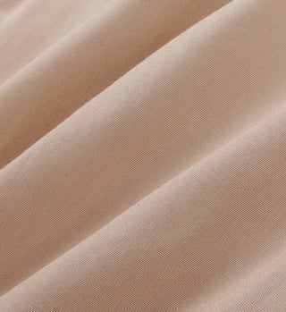 A close-up of the light tan woven fabric shows soft folds and shadows, reminiscent of H&W Crest Oversized Shirt in Portugal.