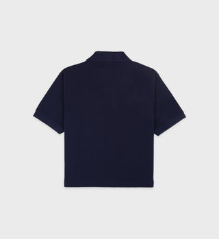 Back view of a H&W Crest Pique Polo in navy with white accents, featuring a cotton pique texture and short sleeves, against a plain background.