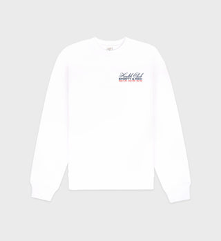 The Made In USA Crewneck - White/Navy/Fire Red is a 100% cotton, garment-dyed white long-sleeve sweatshirt with small Health Club, growing old is rich text on the upper left chest. Made in the USA.
