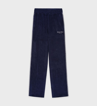 Script Velour Track Pants - Navy/Cream laid flat on a white background, featuring white side stripes, embroidered left thigh text, and crafted from 100% cotton velour.