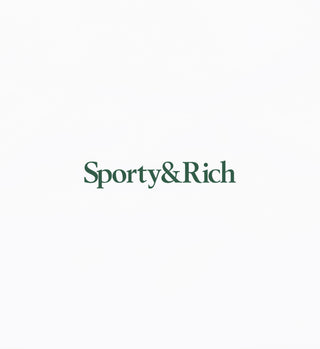 The Serif Logo Disco Short - White/Forest features the Sporty&Rich logo in dark green serif font on a crisp white base, reflecting the timeless style of their American-made heavy jersey shorts.