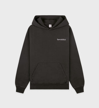 The Serif Logo Hoodie in Faded Black/White is made from USA-grown cotton and features Garment Dyed fabric, a front pocket, and Sporty & Rich text on the left chest, shown on a white background.