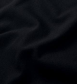 Close-up of the Serif Logo Training Tee in black and white, showcasing its smooth luxury fabric with soft folds creating a wavy texture.