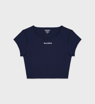 The Serif Logo Training Tee - Navy/White is a luxury activewear crop top featuring Sporty & Rich text on the chest, shown against a white background.