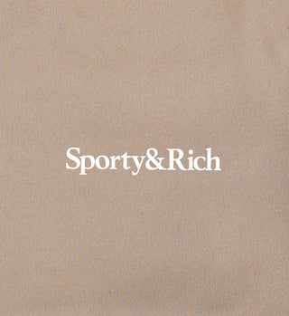 The Serif Logo V Neck Sports Bra in Elephant/White showcases the luxury activewear appeal of Sporty & Rich against a textured beige backdrop, blending elegance with sportiness.