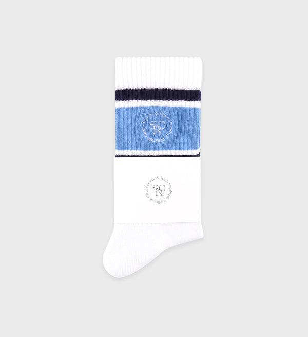 The SRHWC Roller Socks in White/Juniper/Navy feature blue and black stripes, an embroidered logo, and a designer label. 