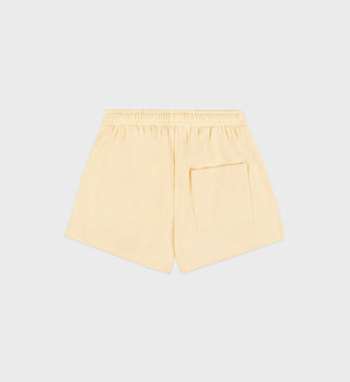 The SR Runner Soft Disco Short in Almond/Navy features a light yellow color, elastic waistband, and a single back pocket, shown on a plain background.