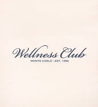 The Wellness Club Embroidered Sweatpant in Cream/Navy features Wellness Club Monte Carlo - Est. 1994 in elegant script on an off-white background. Made in Portugal from 100% cotton for comfort and quality.