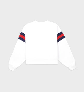 The Wellness Ivy Rugby Crewneck in white, featuring red and navy sleeve stripes, is shown from the back against a plain background.
