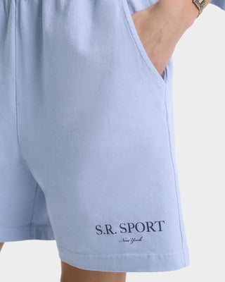 Male model in SR Sport Gym Short - Washed Hydrangea/Navy, elastic waistband, hand in pocket on a white background. 